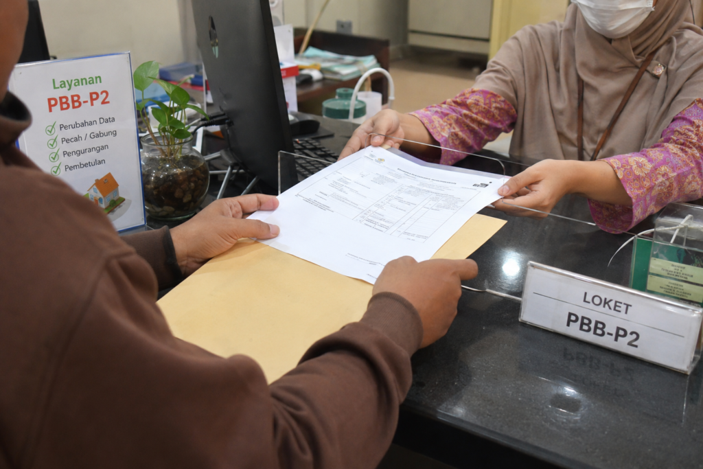 Petugas melayani warga yang mengurus balik nama SPPT PBB di kantor pelayanan pajak daerah.